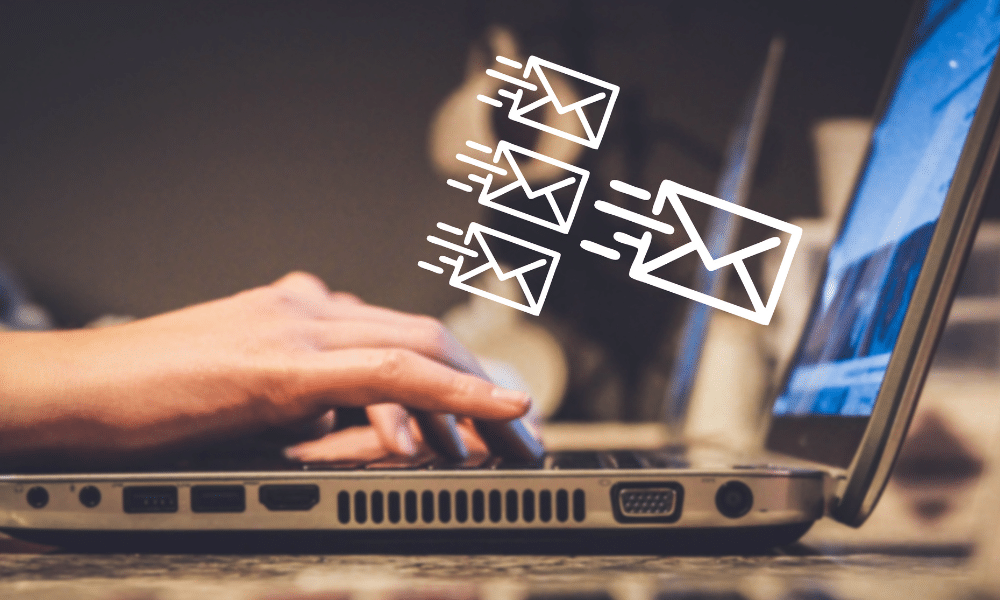 Person typing with email icons flying